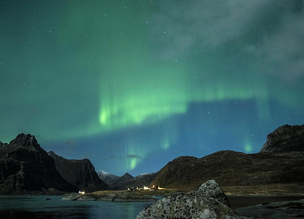 Northern lights illuminating the snowy landscape in Tromsø, Norway