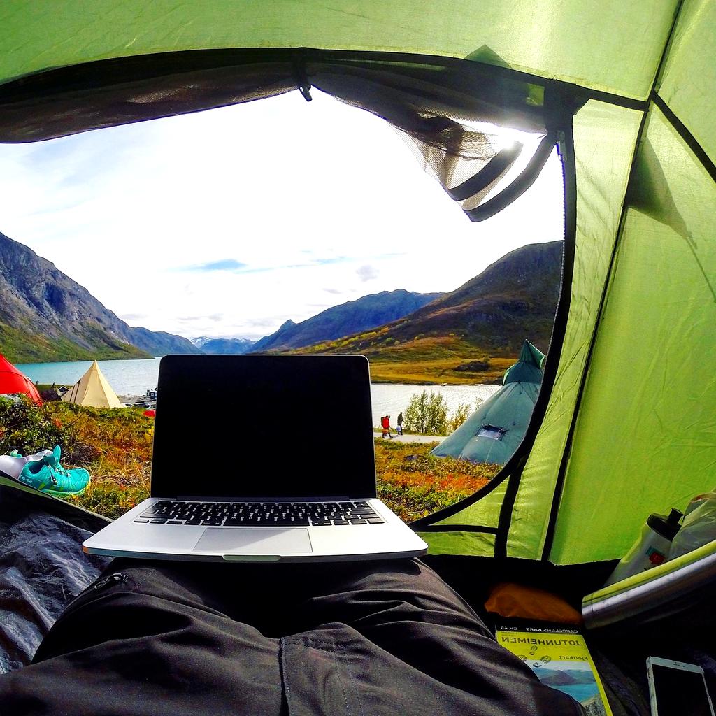 Person planning a travel itinerary on a laptop with a map